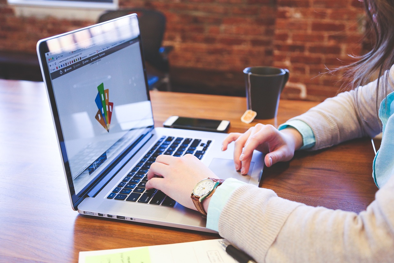 Female commercial broker working on a computer, researching Denver office space options to provide expert guidance for tenants.